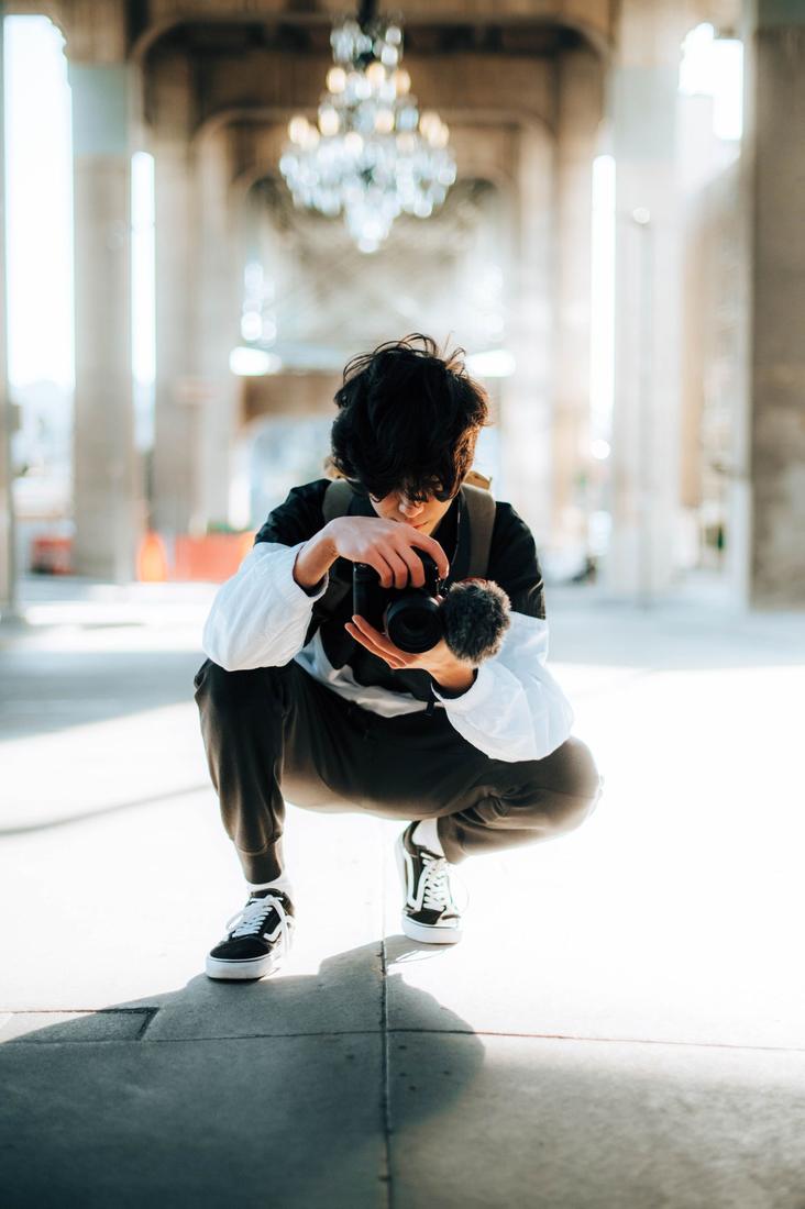 A photographer crouching with a camera