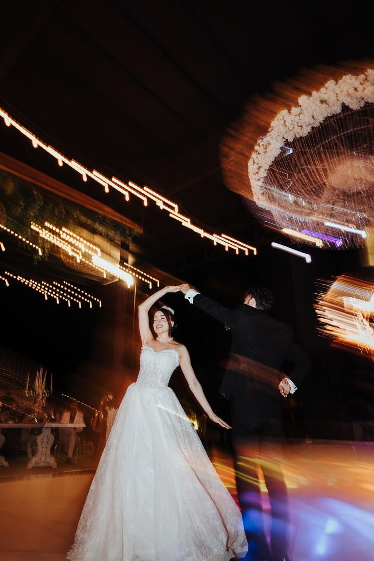 A bride and groom dancing under streaks of light